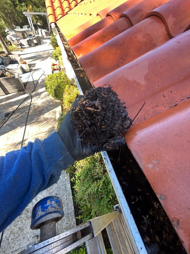 Clearing packed debris from a tile roof gutter